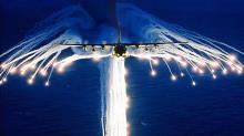 A C-130 H dispensing heat flares for protection against missiles.